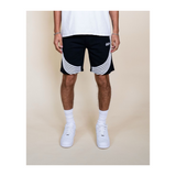 Person wearing black shorts with white stripes on a beige background